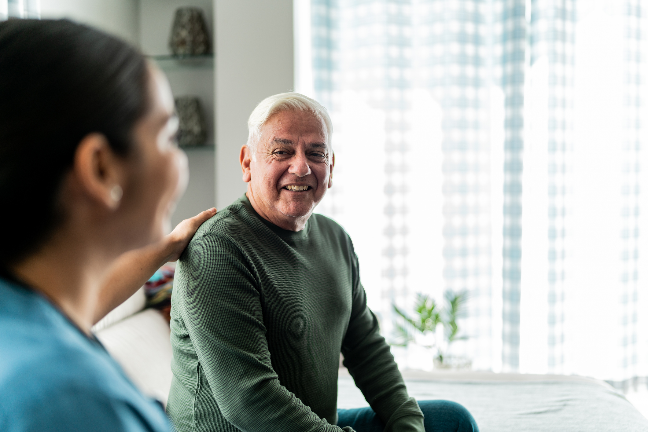 Senior man talking with home caregiver in a medical appointment at home Senior man talking with home caregiver in a medical appointment at home