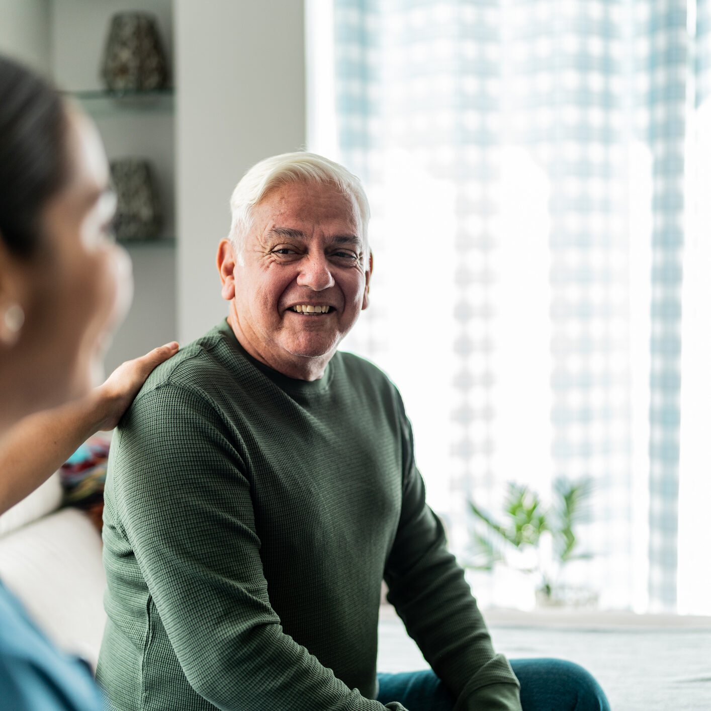 Senior man  talking with home caregiver in a medical appointment at home